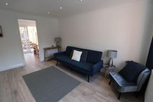 格兰瑟姆Amaya Three - Newly Renovated - Sleeps 6 - Grantham的客厅配有蓝色的沙发和椅子