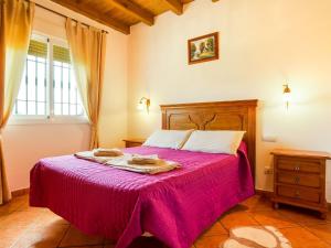 古罗Belvilla by OYO La Vista的一间卧室配有一张带粉色毯子的床