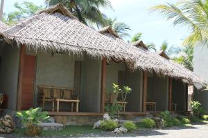 巴图卡拉巴尔卡郎别墅的茅草屋顶和棕榈树的房子