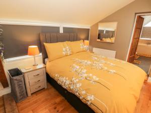 卡纳芬Rhiw Afallen的一间卧室配有黄色的床,床上有鲜花