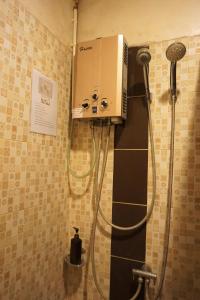 湄林班苏安玛雅旅馆的带淋浴的浴室,墙上配有一台机器