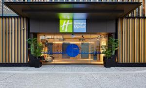 悉尼Holiday Inn Express Sydney Airport, an IHG Hotel的前面有两株盆栽植物的商店