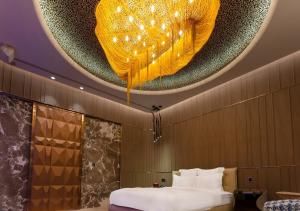 高雄御宿汽车旅馆中华馆的客房设有一张床和带吊灯的天花板