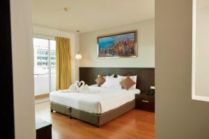 素叻Rhienchai Place Hotel的卧室配有一张大床,墙上挂有绘画作品