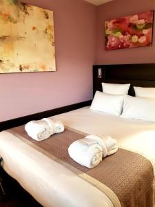 日内瓦Nash Pratik Hotel的两张位于酒店客房的床,配有毛巾