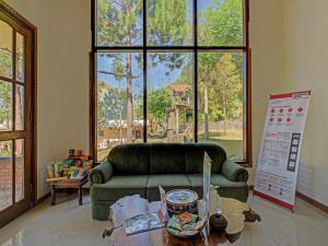 Kemloko-gedeSuper OYO 3208 Villa Inn App Trawas Bintaro Syariah的客厅配有绿色沙发和桌子