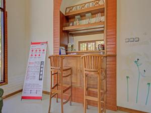 Kemloko-gedeSuper OYO 3208 Villa Inn App Trawas Bintaro Syariah的厨房设有酒吧,配有两张凳子和标志