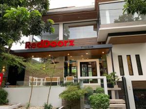 LagunaRedDoorz at Anton's Loft Designer Resort Pansol Calamba Laguna的大楼内有标志的红色门餐厅