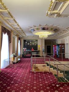 阿斯塔纳雄狮酒店的大房间设有吊灯和红地毯