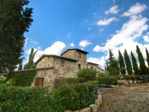 拉达-因基安蒂Belvilla by OYO Limone的一座古老的石头房子,有树木和蓝天