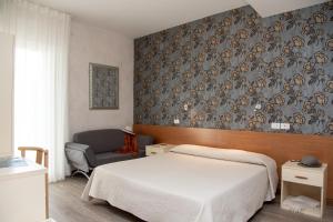利多迪耶索罗罗莎酒店的一间卧室配有一张床和一把椅子