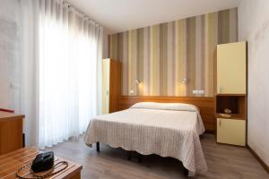 利多迪耶索罗罗莎酒店的一间卧室配有一张床和一台电视