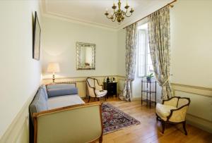 克罗萨克Manoir de Bel Ébat的一间卧室配有一张床、两把椅子和镜子