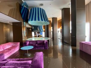 巴里JR Hotels Bari Grande Albergo delle Nazioni的大堂设有紫色沙发和蓝色吊灯