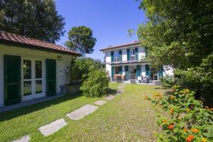 马里纳迪马萨Villa Victor 100m from sea - Happy Rentals的一座带绿门的房屋和一座鲜花庭院