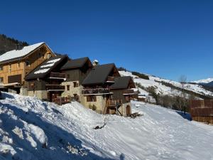 瓦尔莫雷尔Chalet Lucie LE CHEVAL NOIR的雪覆盖的滑雪场顶上的滑雪小屋
