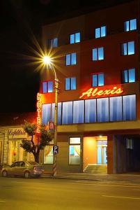 克卢日-纳波卡阿莱克斯酒店的楼前有 ⁇ 虹灯标志的酒店