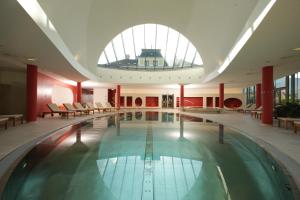 巴德伊舍赛勒恩维托度假别墅的一座大型游泳池,位于一座带大窗户的建筑内