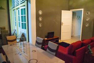 圣多美Sky Nautico Apartment的客厅配有桌子和红色沙发