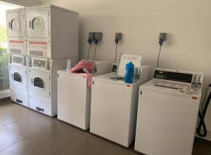 圣地亚哥Depto Estoril Clinica Las Condes的一间配备有洗衣机和其他家电的房间
