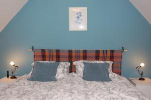 SkeabostDonmar Cottage的一间卧室配有带2个枕头的床