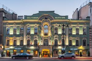 圣彼得堡Helvetia Hotel的一座大型建筑,前面有汽车停放