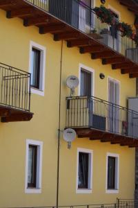 奥斯塔Eleonora’s Home的黄色的建筑,设有窗户和阳台