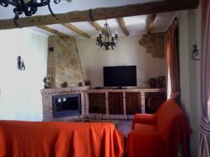 扎哈拉Casa Rural-Apartamento El Lebrillero的客厅配有电视、桌子和壁炉