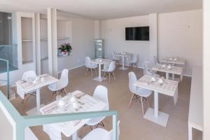 马瑟利Camere Relais Filomare的用餐室配有白色的桌子和白色的椅子