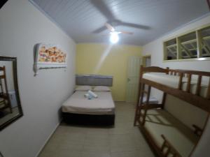阿布拉奥Ilha Grande Mar的小客房设有两张双层床和吊扇。