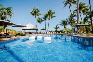 圣吉尔莱班白鹭酒店的一个带椅子和遮阳伞的游泳池以及棕榈树