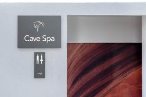 雅典Glyfada Riviera Hotel的棕色头发墙上的洞穴温泉标志