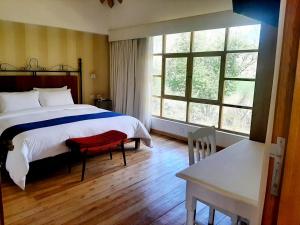 乌鲁班巴卡索纳萨格拉多酒店的卧室配有床、桌子和窗户。