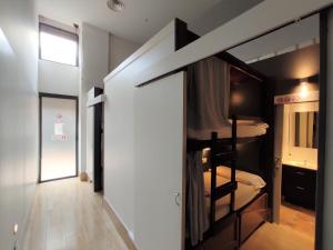 巴塞罗那巴塞罗那蚂蚁旅舍的客房设有双层床和走廊。