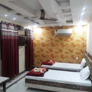 坎普尔Kartar Yatri Niwas的墙上的房间里设有两张床