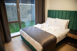 ÇankayaINN HOUSE LOFT SPA的一张带绿色床头板的床,位于带窗户的房间里