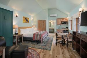 摩押Moab Springs Ranch的一间卧室配有一张床,厨房配有桌子