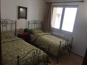 阿西西Residenza La Luce di Assisi的一间卧室设有两张床和窗户。