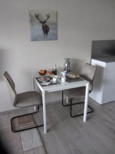 哈嫩克利博克斯维斯Appartement Ausblick的一张带两把椅子的白色桌子和白色冰箱