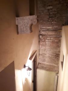 阿西西Residenza La Luce di Assisi的走廊上设有石墙和墙上的灯