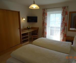 卡尔蒂奇玛丽亚旅馆的酒店客房设有两张床、一张书桌和一个窗户。