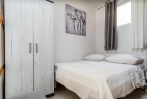 斯普利特Apartment Tomas的卧室配有白色橱柜和1张床