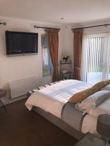 纽里Clanrye House Guest Accommodation的一间卧室配有一张大床和一台平面电视