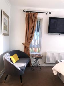 纽里Clanrye House Guest Accommodation的客厅配有椅子和电视