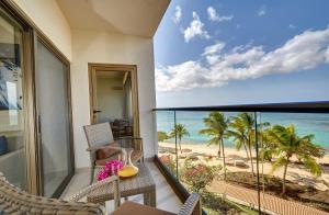 BambooRoyalton Grenada, An Autograph Collection All-Inclusive Resort的一个带椅子的阳台,享有海滩美景