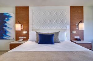 BambooRoyalton Grenada, An Autograph Collection All-Inclusive Resort的一间卧室配有一张带蓝色枕头的大床