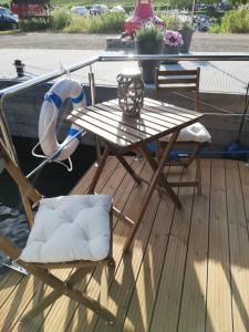 PölichHausboot auf der Mosel的船上的木制甲板上配有桌椅