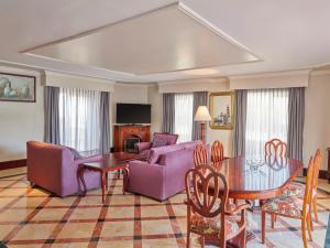 阿瓜斯卡连特斯美洲阿瓜斯卡连特斯嘉年华酒店的客厅配有紫色家具和桌子