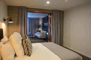 基督城Southwark Hotel & Apartments的一间卧室设有一张床和一间客厅。