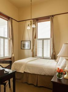 Three Forks撒卡亚维酒店的一间卧室配有一张床、一张书桌和两个窗户。